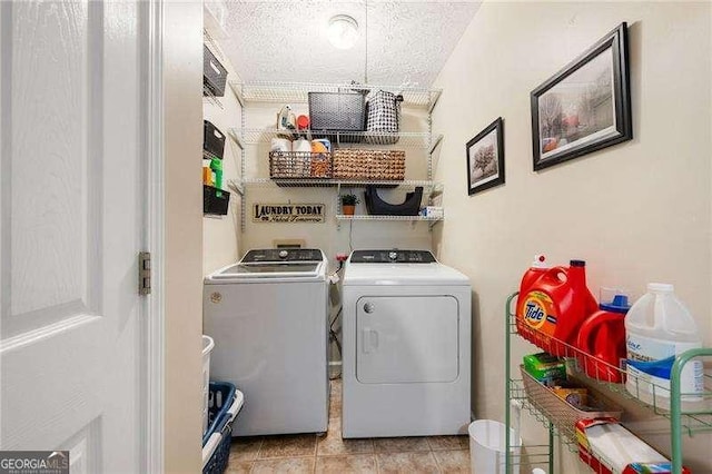 laundry area featuring light tile patterned floors, a textured ceiling, and independent washer and dryer