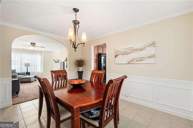 dining space with ceiling fan with notable chandelier, ornamental molding, and light tile patterned flooring