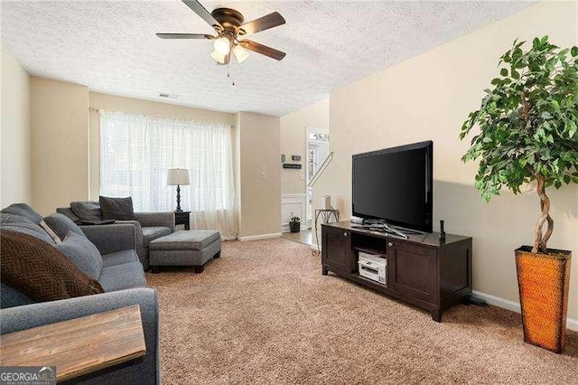 living room featuring ceiling fan, light carpet, and a textured ceiling