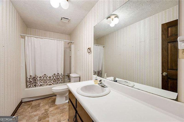 bathroom featuring vanity, toilet, and a textured ceiling