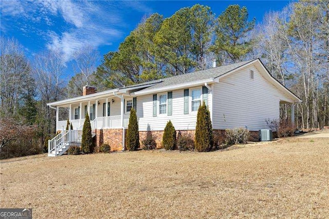 view of front of house with central AC, a front lawn, and a porch