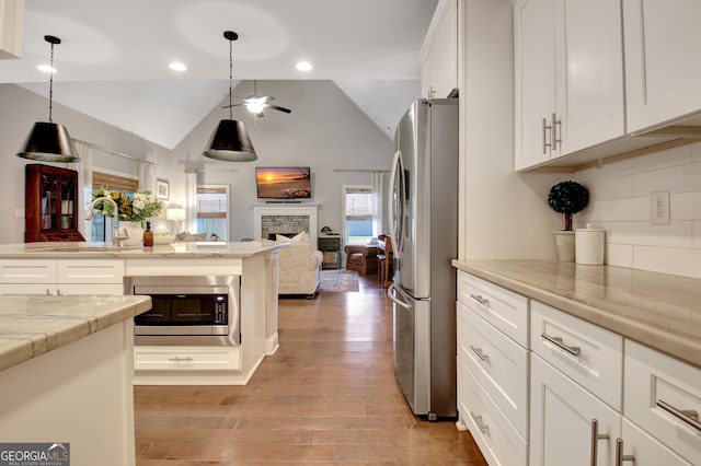 kitchen with white cabinetry, sink, decorative light fixtures, and appliances with stainless steel finishes