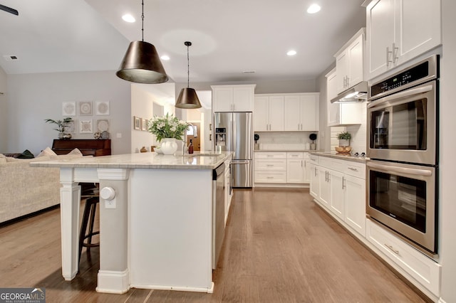 kitchen featuring sink, white cabinetry, decorative light fixtures, a center island, and appliances with stainless steel finishes