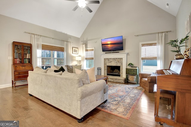 living room featuring hardwood / wood-style flooring, ceiling fan, a fireplace, and a wealth of natural light