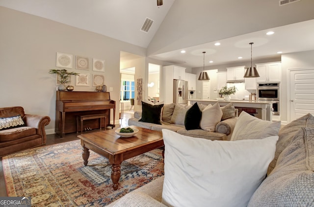 living room featuring high vaulted ceiling