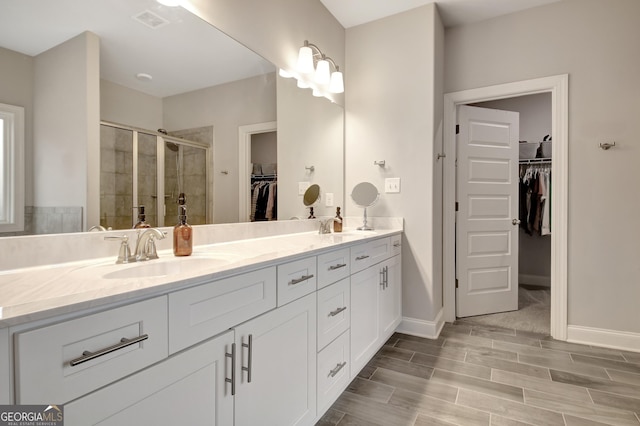 bathroom featuring vanity and a shower with door