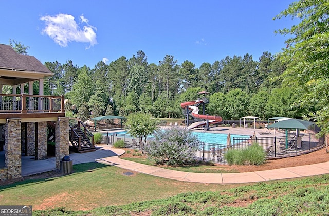 view of pool with a water slide and a patio area