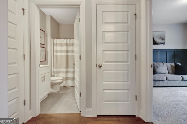 bathroom with wood-type flooring, toilet, and vanity