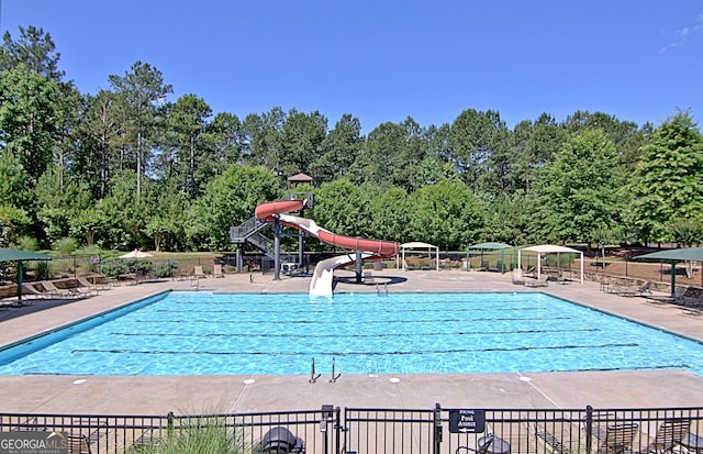 view of pool featuring a water slide and a patio area