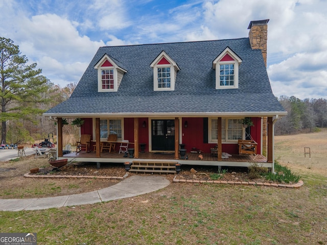 country-style home with a porch, a chimney, and a shingled roof