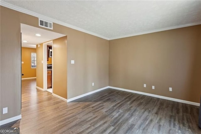 unfurnished room featuring crown molding, dark wood-type flooring, and a textured ceiling