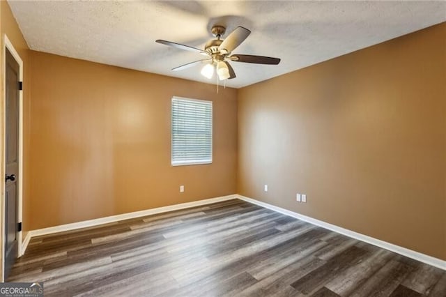 empty room featuring dark wood-type flooring, a textured ceiling, and ceiling fan