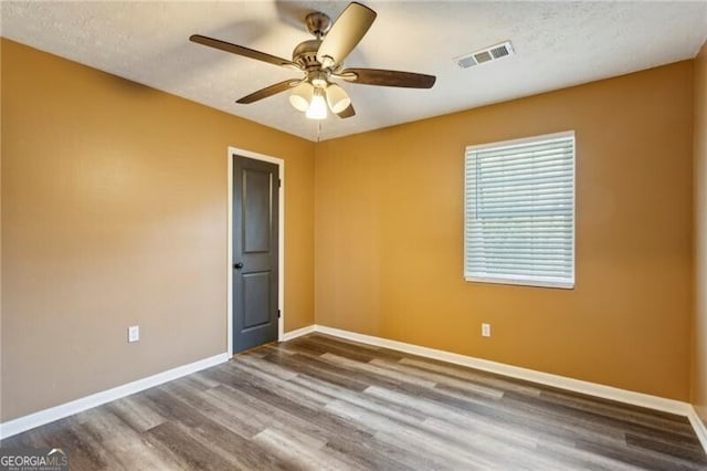 spare room featuring hardwood / wood-style flooring, a textured ceiling, and ceiling fan