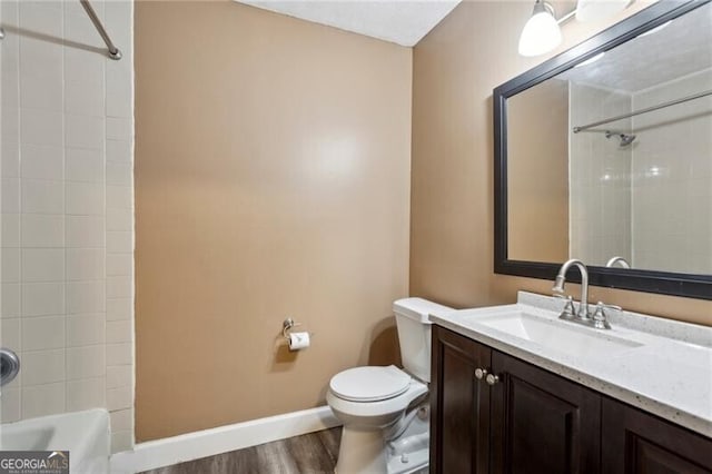 full bathroom with vanity, tiled shower / bath, wood-type flooring, and toilet