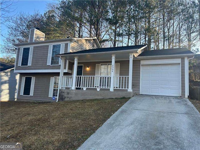 tri-level home featuring a porch, a garage, and a front lawn