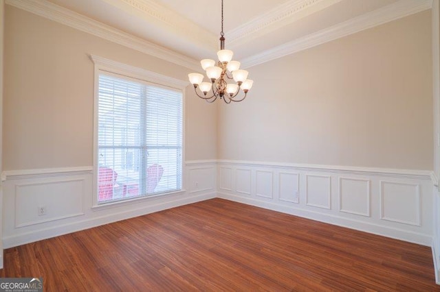 empty room featuring an inviting chandelier, crown molding, dark hardwood / wood-style flooring, and a tray ceiling