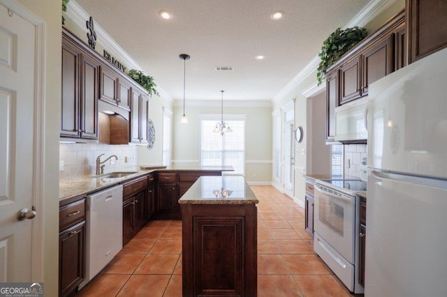 kitchen featuring sink, crown molding, white appliances, a kitchen island, and decorative light fixtures