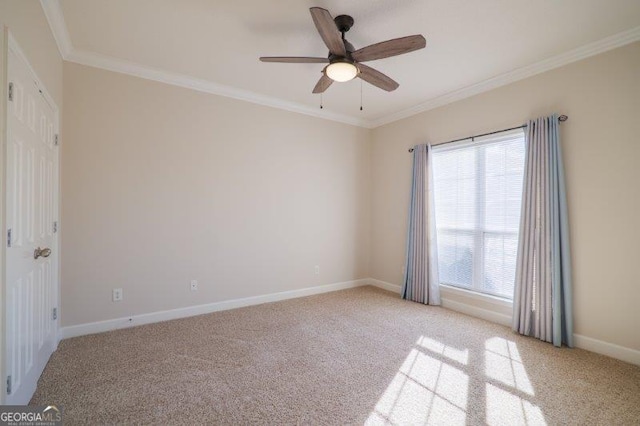 carpeted spare room featuring crown molding and ceiling fan