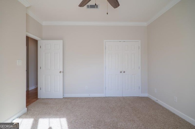 unfurnished bedroom with ornamental molding, light carpet, ceiling fan, and a closet