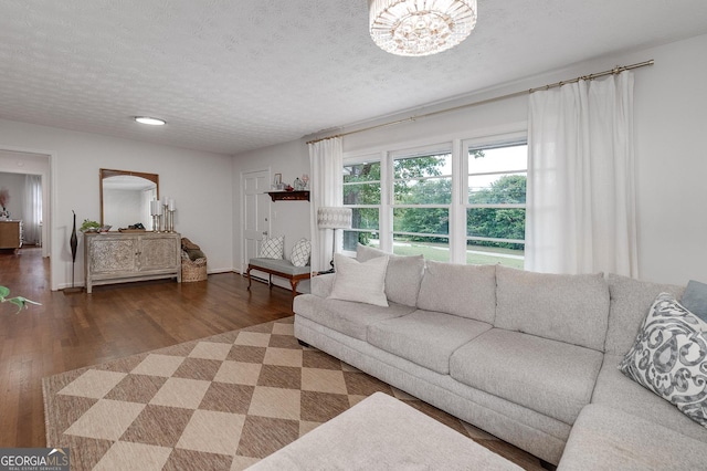 living room featuring an inviting chandelier, hardwood / wood-style floors, and a textured ceiling