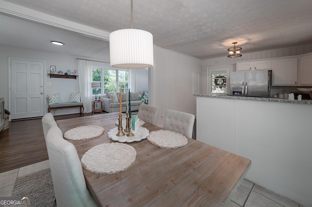 dining space with a textured ceiling and light tile patterned floors