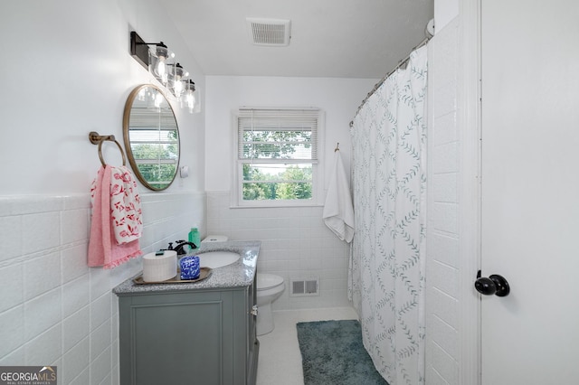 bathroom featuring tile patterned flooring, tile walls, vanity, a shower with curtain, and toilet