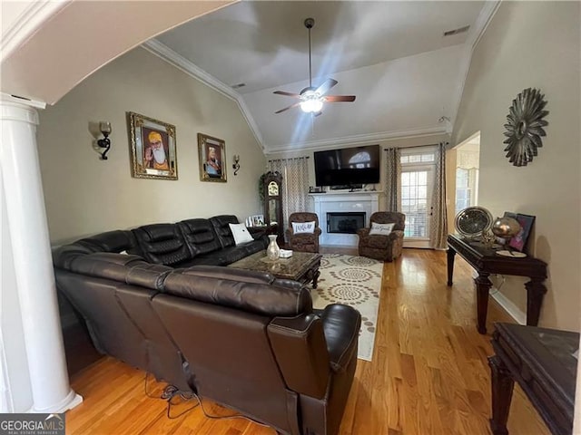 living room featuring crown molding, lofted ceiling, decorative columns, and light wood-type flooring