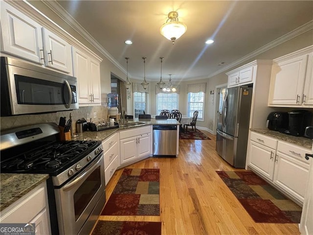 kitchen featuring light hardwood / wood-style flooring, ornamental molding, appliances with stainless steel finishes, kitchen peninsula, and white cabinets