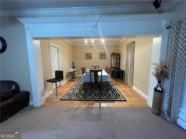 dining room featuring light colored carpet and ornamental molding