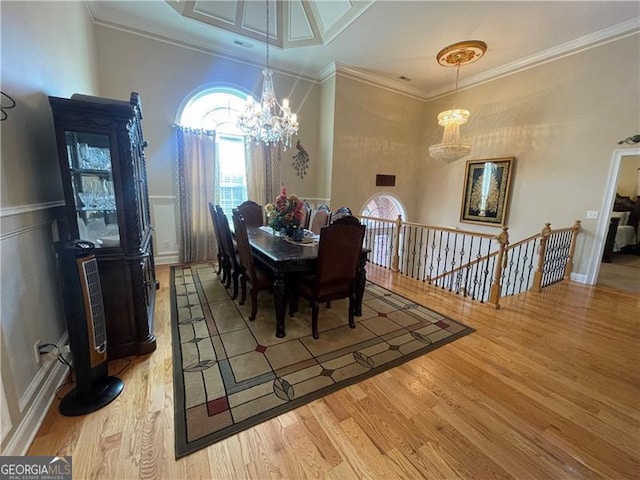 dining room with a notable chandelier, hardwood / wood-style flooring, and ornamental molding