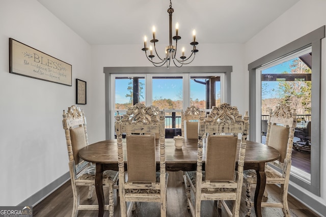 dining room with an inviting chandelier, a healthy amount of sunlight, and dark hardwood / wood-style floors