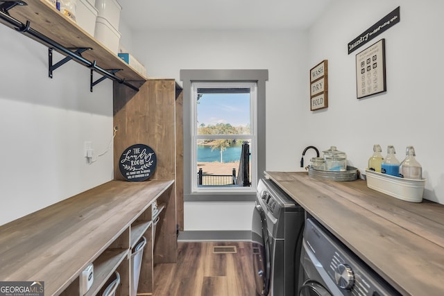 clothes washing area with indoor bar, dark hardwood / wood-style floors, and washing machine and dryer