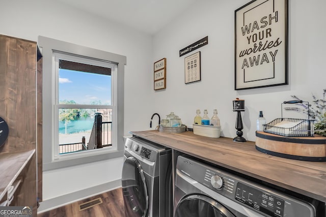 laundry room featuring dark hardwood / wood-style flooring, independent washer and dryer, and bar