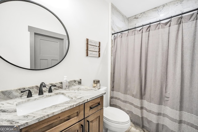 bathroom featuring vanity, curtained shower, and toilet