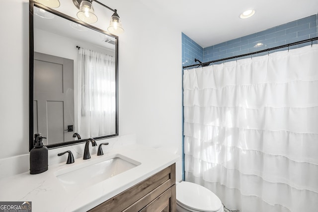 bathroom with vanity, curtained shower, and toilet