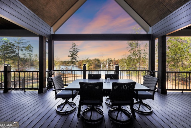 deck at dusk featuring a water view