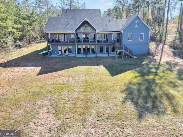 rear view of property with a yard, a deck, and a patio area