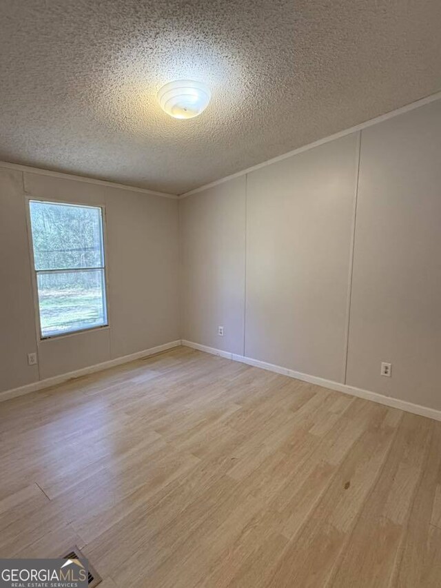 unfurnished bedroom featuring hardwood / wood-style flooring, vaulted ceiling, and a textured ceiling