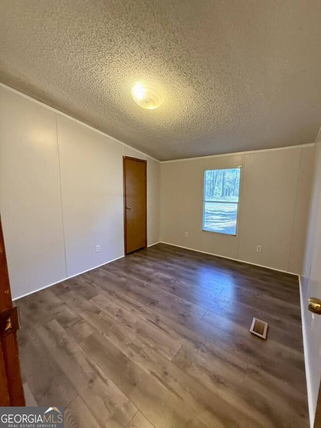 unfurnished room featuring ornamental molding, a textured ceiling, and light wood-type flooring