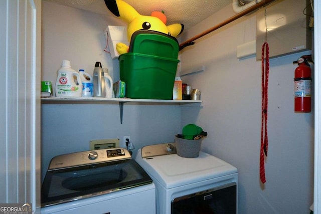 washroom with washer and dryer and a textured ceiling