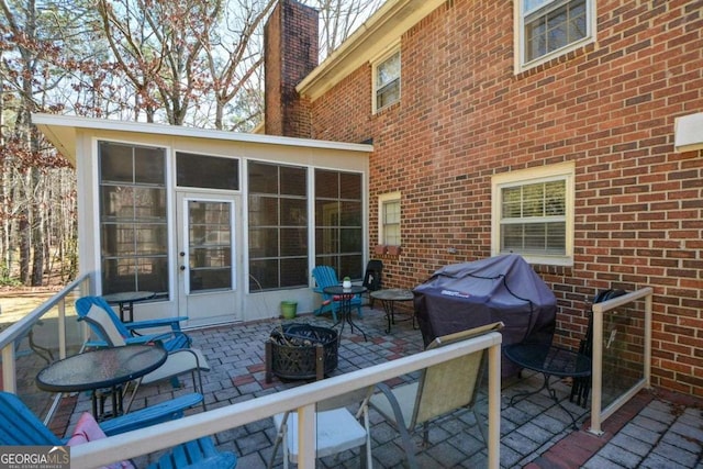 view of patio / terrace with a sunroom and a grill