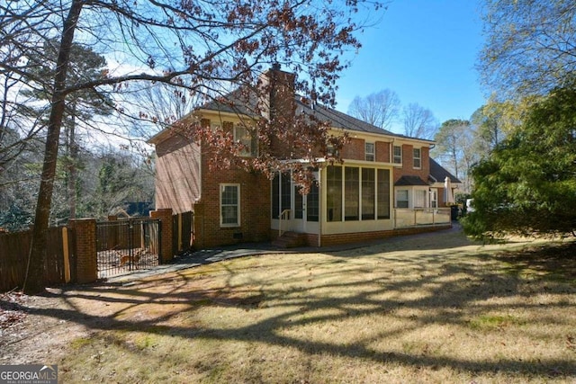 rear view of property with a yard and a sunroom