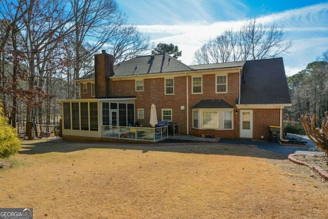 back of property featuring a sunroom and a lawn