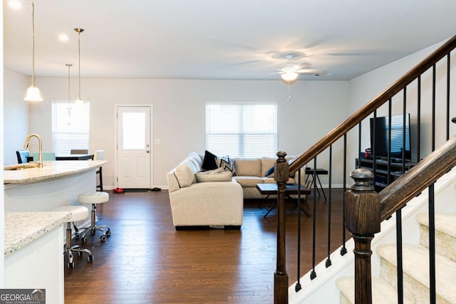 living room featuring sink, dark wood-type flooring, a healthy amount of sunlight, and ceiling fan