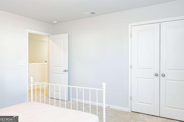 unfurnished bedroom with light colored carpet and a closet