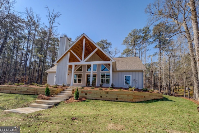 view of front of home featuring a shingled roof, a front lawn, board and batten siding, and a chimney