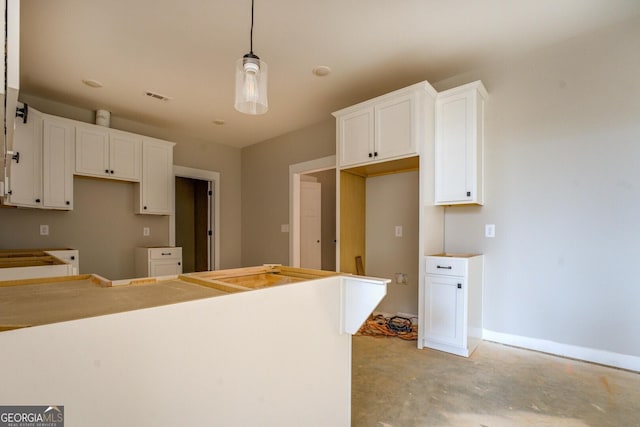 kitchen with visible vents, white cabinetry, baseboards, unfinished concrete floors, and hanging light fixtures