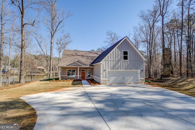 view of front of house with driveway, stone siding, a porch, board and batten siding, and a front yard