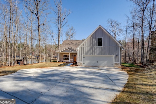 view of front of home with stone siding, a garage, board and batten siding, and driveway