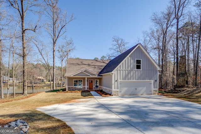 view of front of property with board and batten siding, a front yard, roof with shingles, stone siding, and driveway